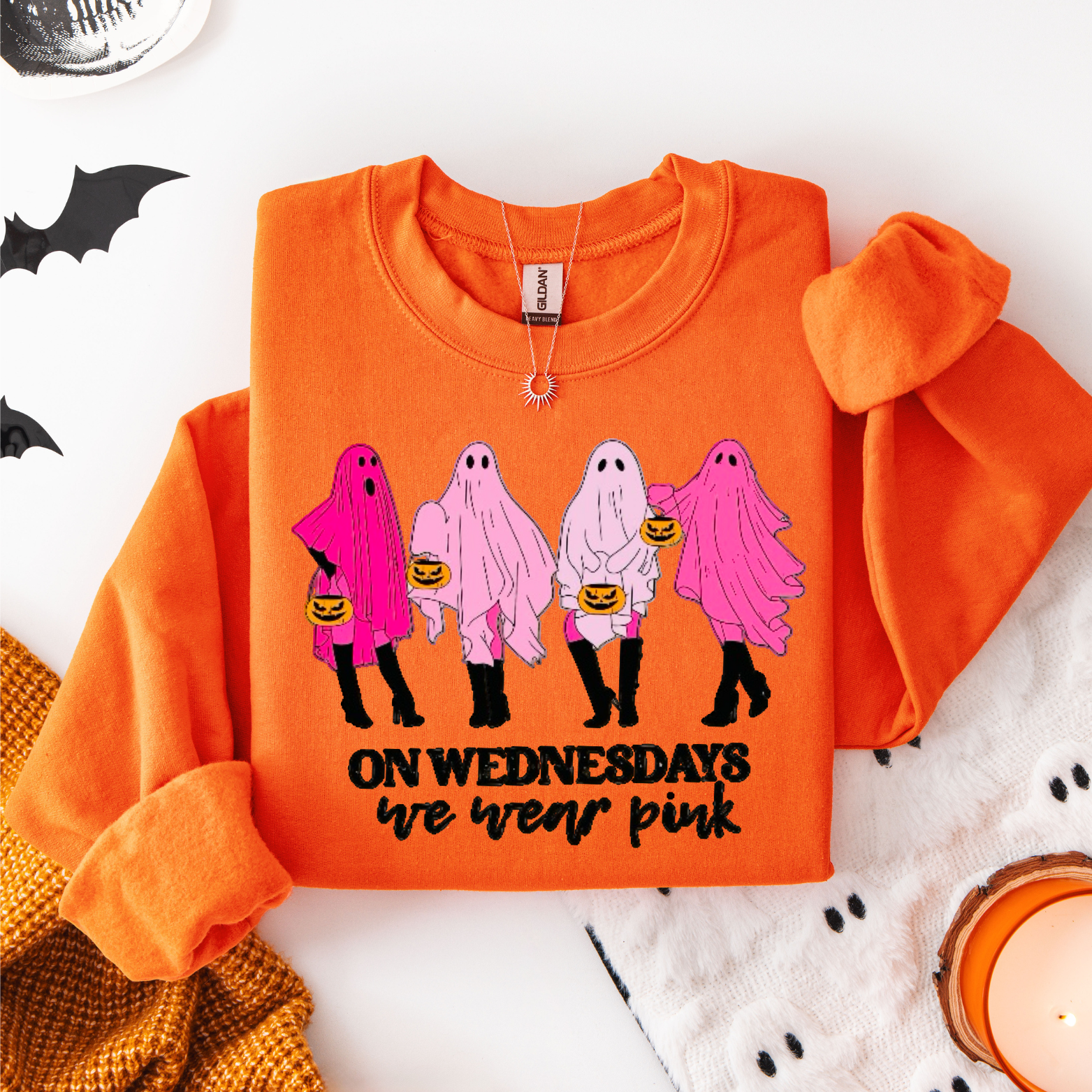 Orange sweatshirt with ghost design and text on a white background