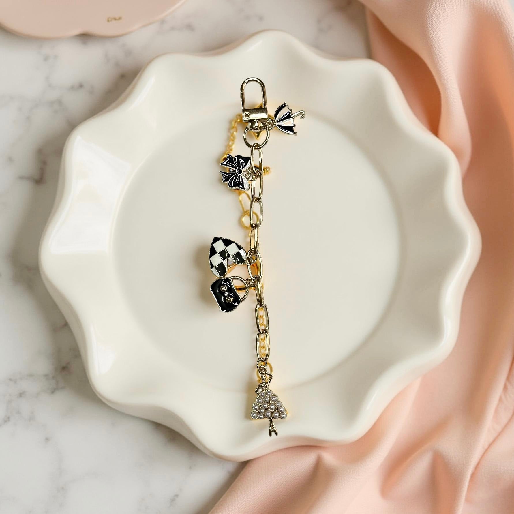 Bracelet with charms on a white dish against a marble background